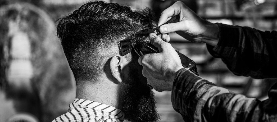 В парикмахерской стрижка мужчины