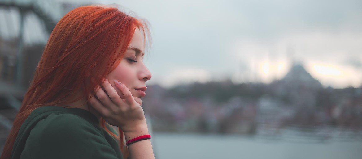 Задумчивая девушка с рыжими волосами